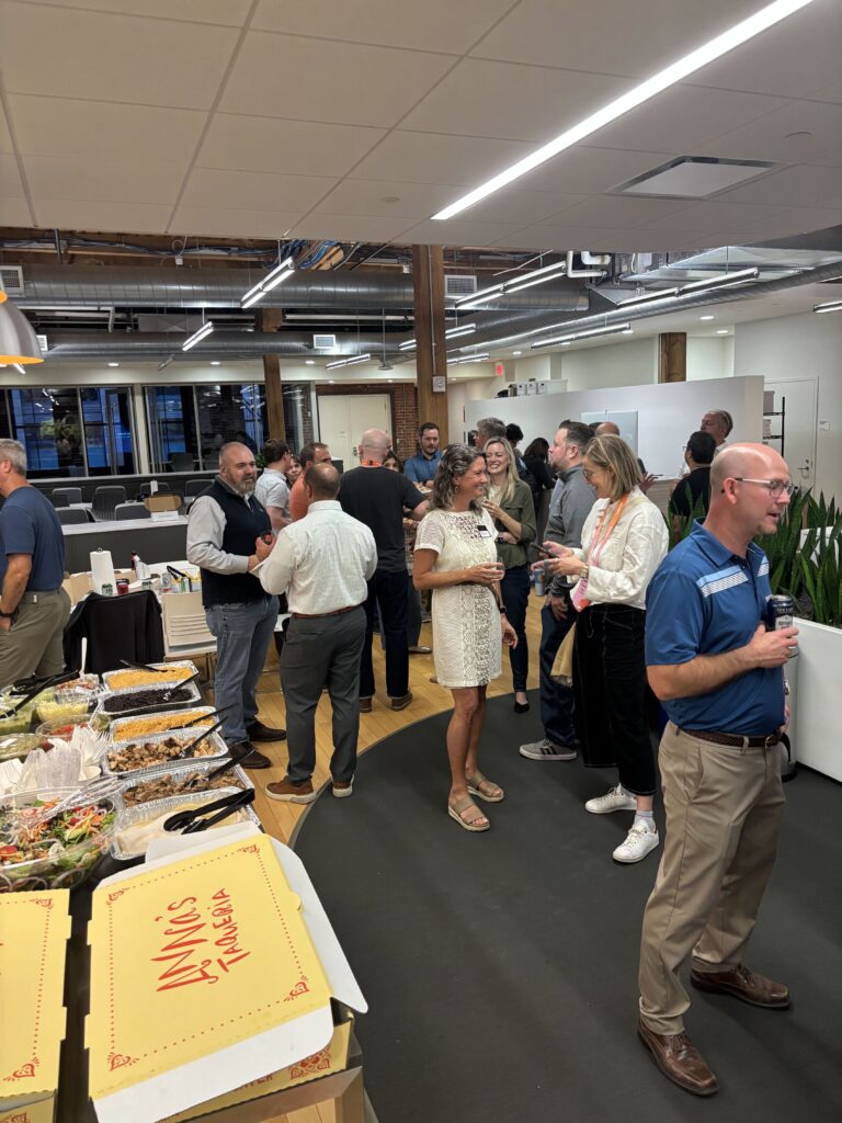 Guests mingling around a taco buffet in a busy open office